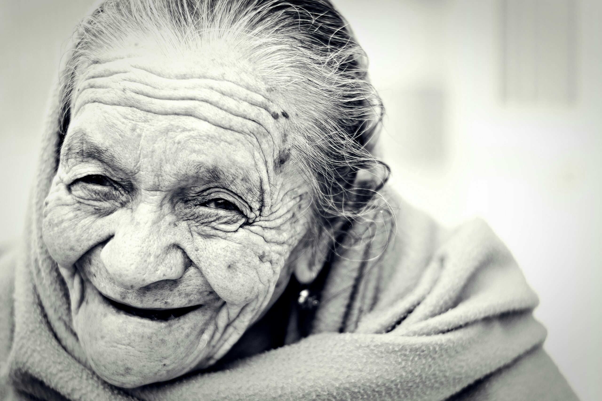 A woman smiling happily while holding a cup of herbal tea featuring Gymnema Sylvestre