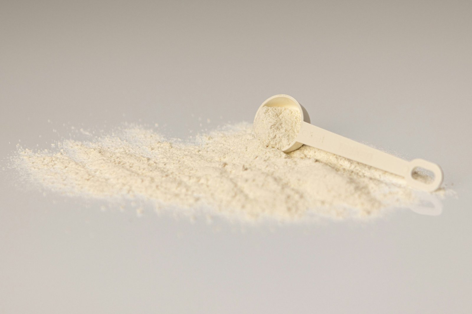 a pile of white powder next to a scoop of powder