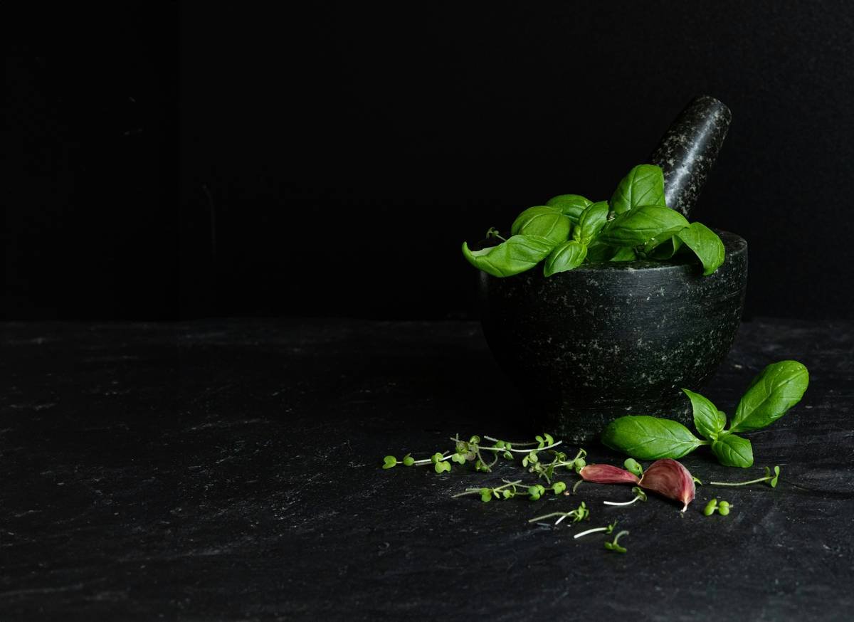 Woman holding a capsule bottle labeled Gymnema Extract