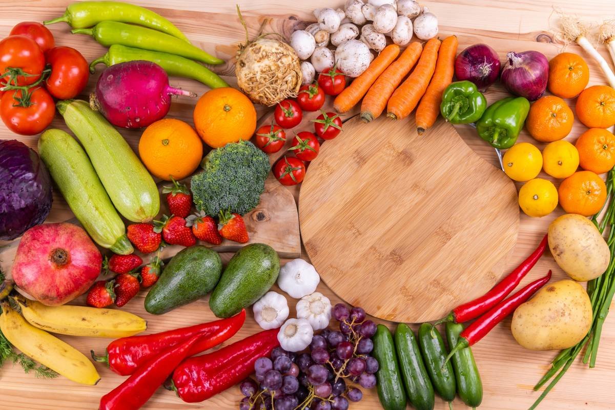 benefits of giving up sugar: person smiling while preparing a colorful salad instead of sugary snacks