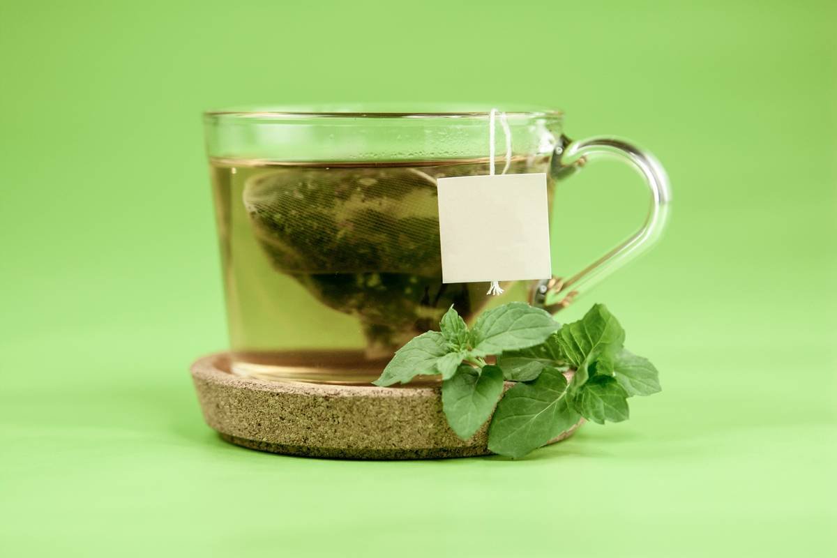 weight gymnema sylvestre reduce: herbal supplement capsules next to fresh gymnema leaves on a wooden table